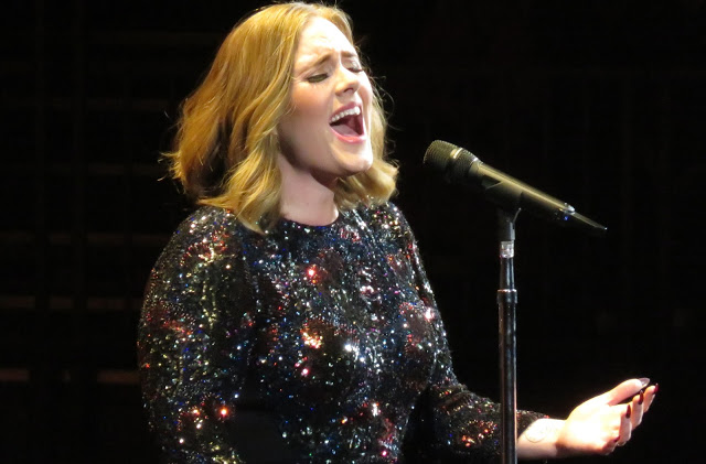 Adele gives moving performance in tribute to Grenfell Tower fire victims. Urges fans to donate.